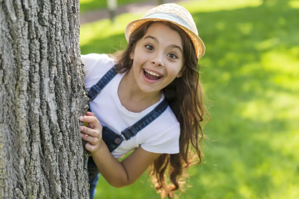 smiley little girl posing tree
